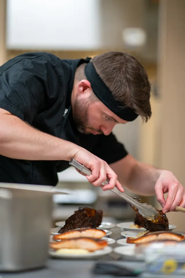 Bobby Howell plating entrées during service at Hosted by Howell